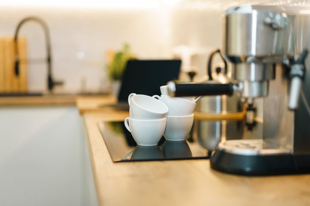 Cafetera de cápsulas sobre la encimera con una taza debajo
