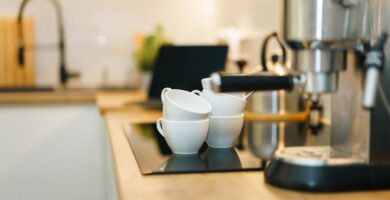 Cafetera de cápsulas sobre la encimera con una taza debajo