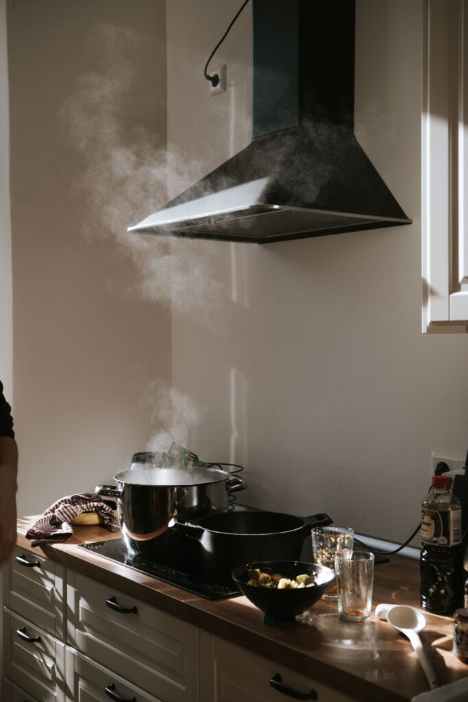 Campana extractora encendida sobre la placa de cocina