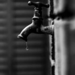 Grifo goteando con una gota cayendo del caño