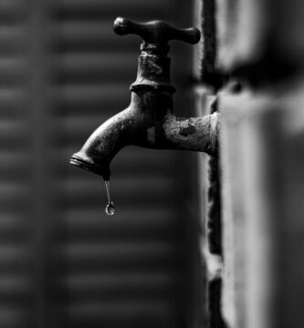 Grifo goteando con una gota cayendo del caño