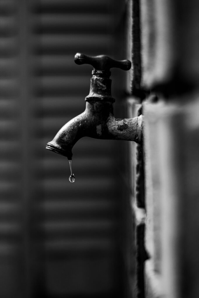 Grifo goteando con una gota cayendo del caño