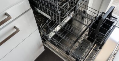 Lavavajillas abierto con la cesta inferior cargada de platos