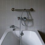 Junta de silicona entre una bañera blanca y la pared alicatada