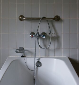 Junta de silicona entre una bañera blanca y la pared alicatada