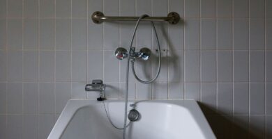 Junta de silicona entre una bañera blanca y la pared alicatada