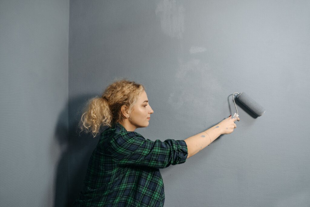 Retocando una pared con rodillo y pintura del mismo color