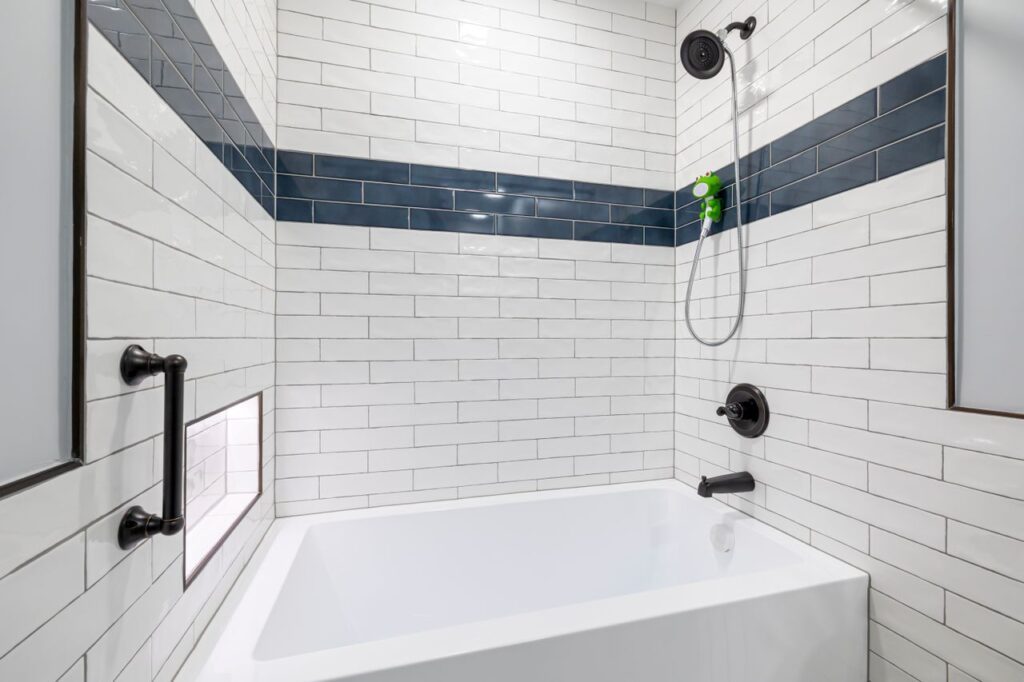 Baño con bañera y ducha de obra con azulejo blanco